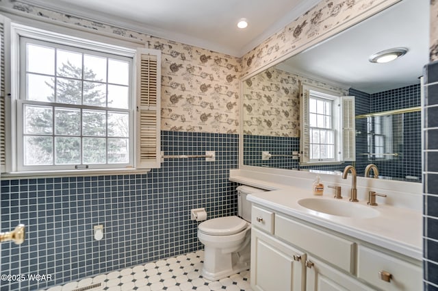 bathroom featuring tile patterned floors, toilet, vanity, ornamental molding, and a shower with door