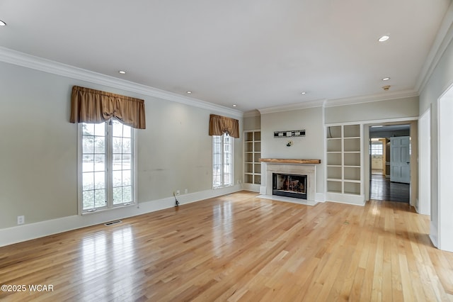 unfurnished living room with built in shelves, light hardwood / wood-style flooring, and ornamental molding