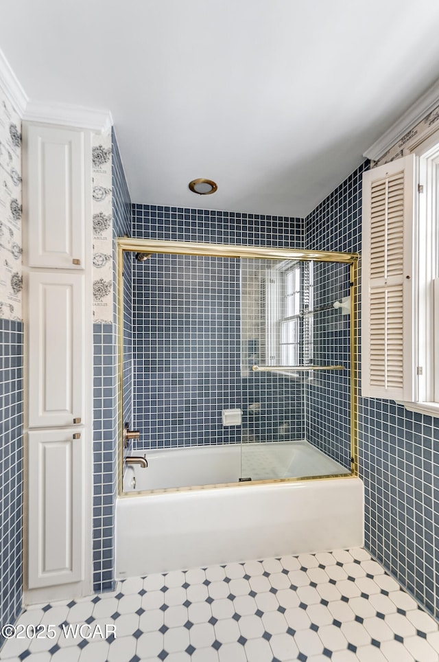 bathroom with crown molding, combined bath / shower with glass door, and tile walls