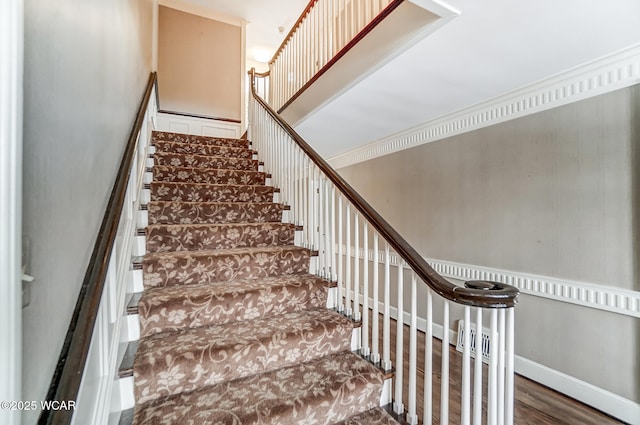 staircase featuring hardwood / wood-style floors and crown molding