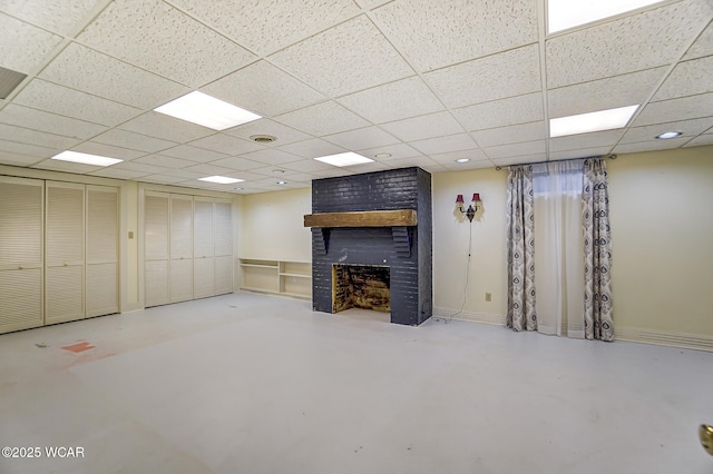 basement featuring a brick fireplace and a paneled ceiling