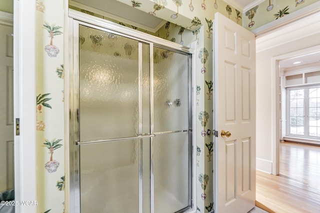 bathroom featuring crown molding, hardwood / wood-style flooring, and walk in shower