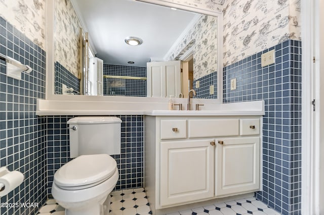 bathroom with tile walls, vanity, ornamental molding, and toilet