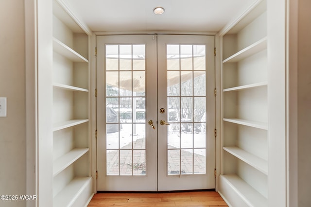 doorway to outside featuring plenty of natural light, light hardwood / wood-style floors, and french doors