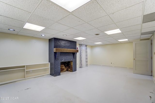 basement with a brick fireplace and a paneled ceiling