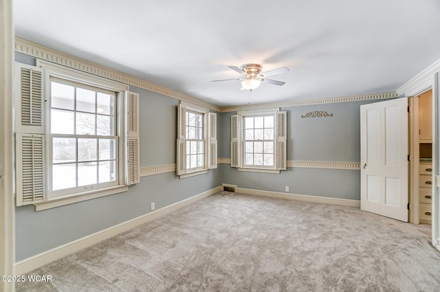 carpeted spare room featuring ceiling fan and ornamental molding