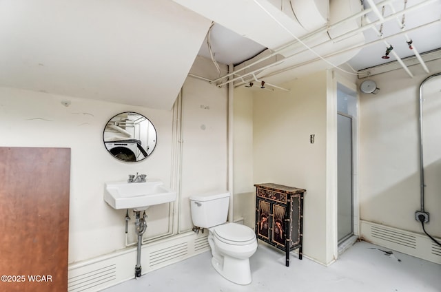 bathroom with sink, concrete flooring, and toilet