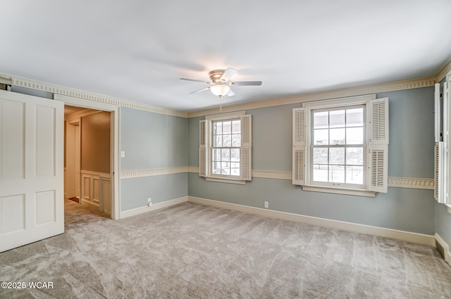 empty room featuring ornamental molding, light carpet, and ceiling fan