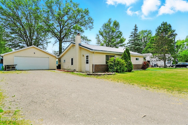 1398 Lutz Rd, Lima, OH 45801 - view of front of house with brick siding, an outdoor structure, a chimney, a detached garage, and a front lawn