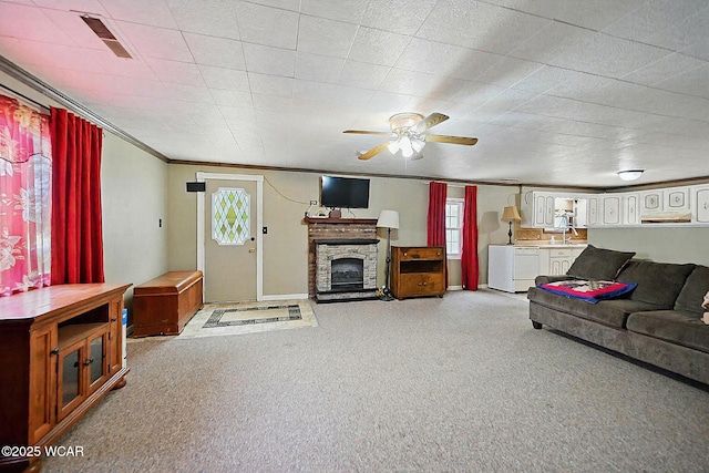 1398 Lutz Rd, Lima, OH 45801 - living area featuring light colored carpet, ceiling fan, ornamental molding, washing machine and dryer, and a stone fireplace
