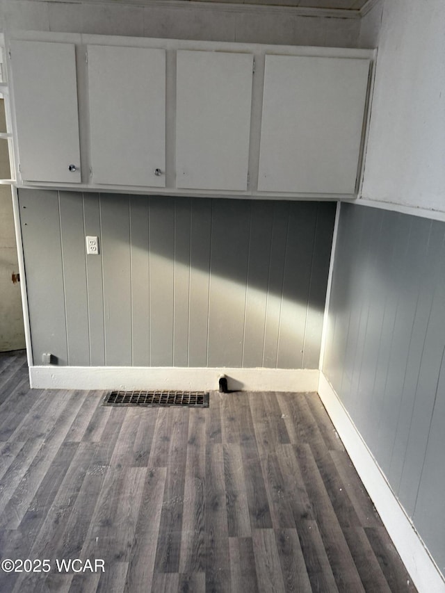 clothes washing area with dark wood finished floors