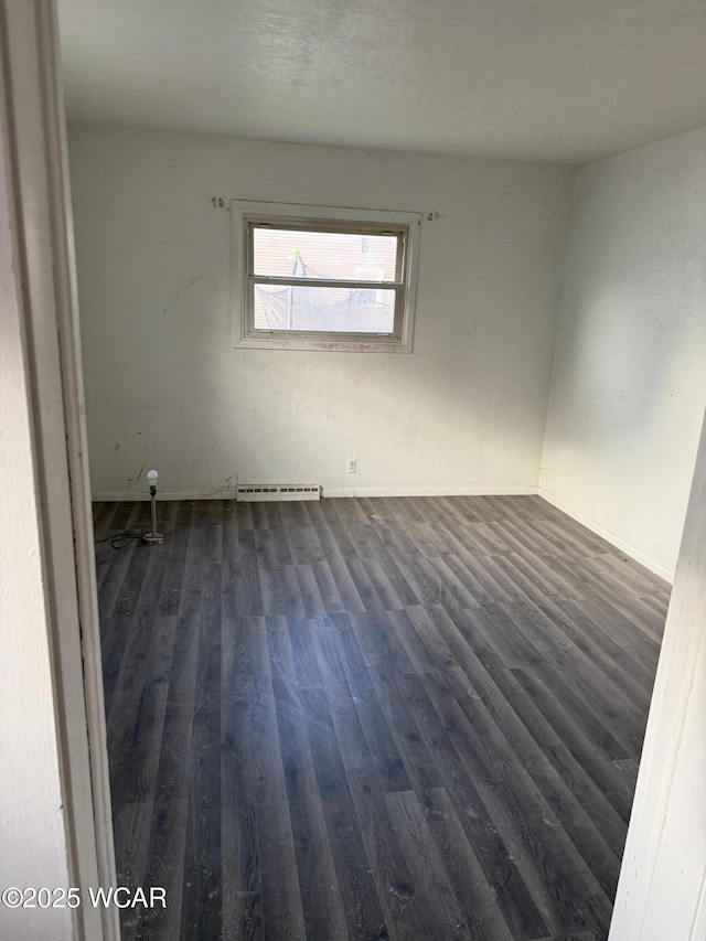 empty room with baseboards and dark wood finished floors