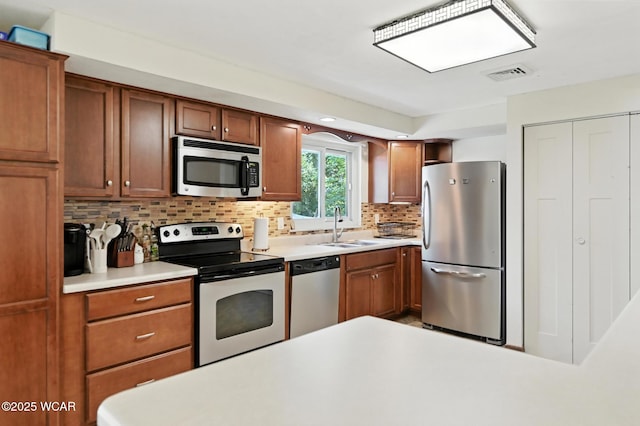 2238 N Glenwood Ave, Lima, OH 45805 - kitchen featuring appliances with stainless steel finishes, backsplash, light countertops, and brown cabinetry