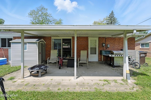 2238 N Glenwood Ave, Lima, OH 45805 - rear view of property featuring an outdoor fire pit, a shed, brick siding, and a patio area