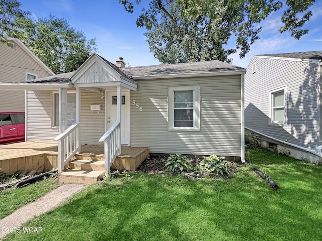 556 Cortlandt Ave, Lima, OH 45801 - bungalow featuring a front yard, a chimney, and a shingled roof