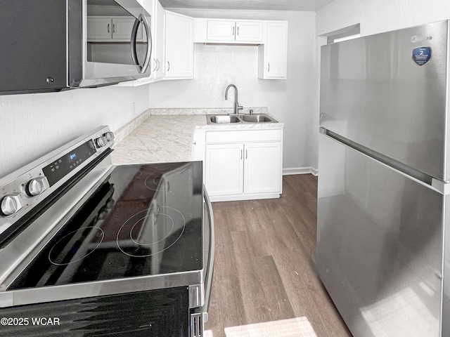 556 Cortlandt Ave, Lima, OH 45801 - kitchen with appliances with stainless steel finishes, wood finished floors, and white cabinetry