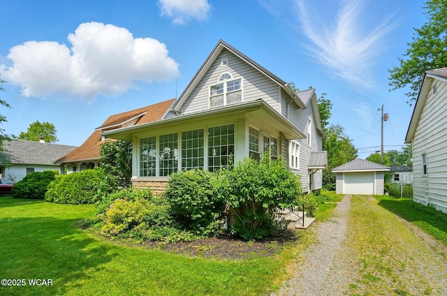 510 N Walnut St, Van Wert, OH 45891 - view of side of home featuring a yard, a detached garage, and a sunroom