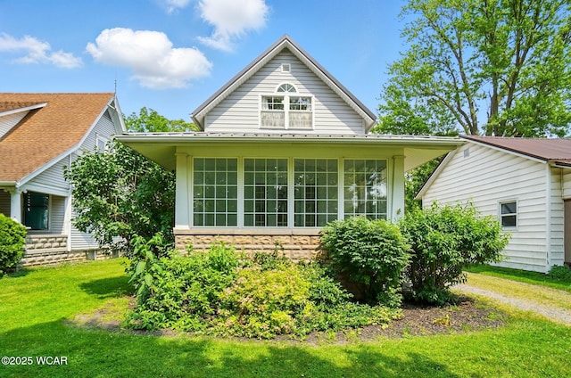 510 N Walnut St, Van Wert, OH 45891 - view of side of home with a lawn, stone siding, and a sunroom