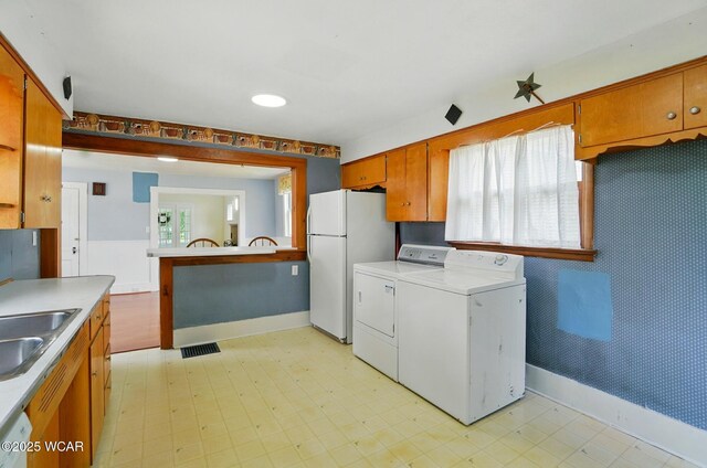 510 N Walnut St, Van Wert, OH 45891 - kitchen featuring freestanding refrigerator, separate washer and dryer, light countertops, brown cabinetry, and light flooring
