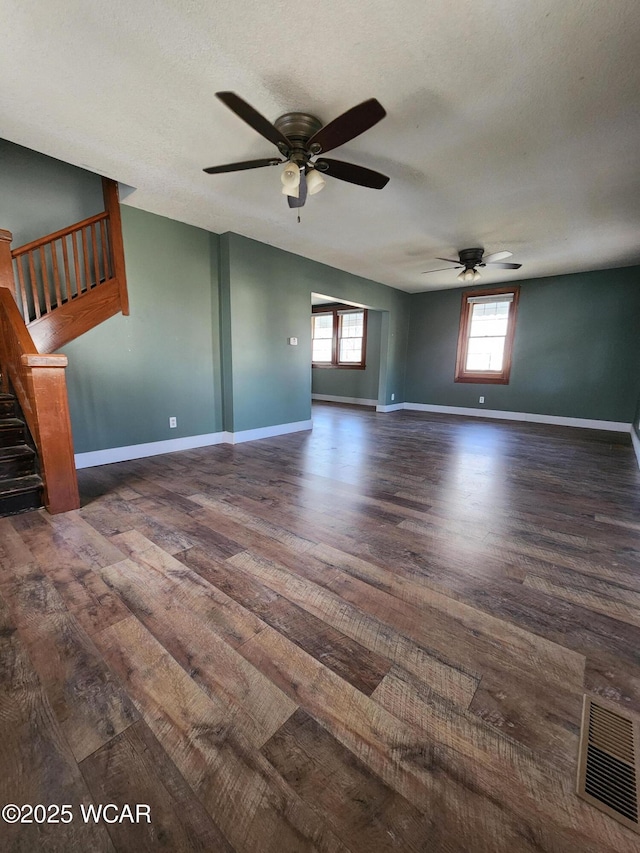 unfurnished room with a textured ceiling, dark wood-type flooring, and ceiling fan