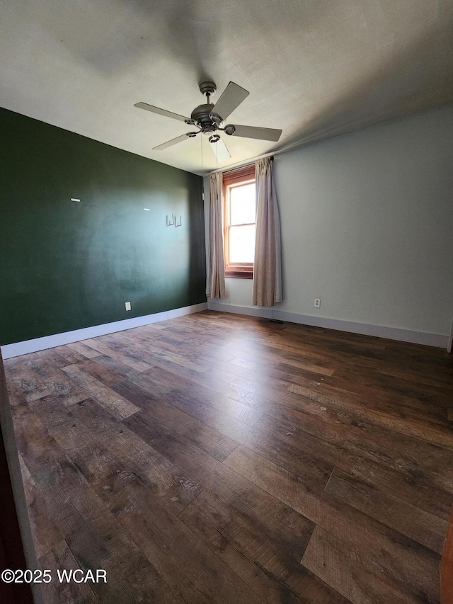 spare room with dark wood-type flooring and ceiling fan