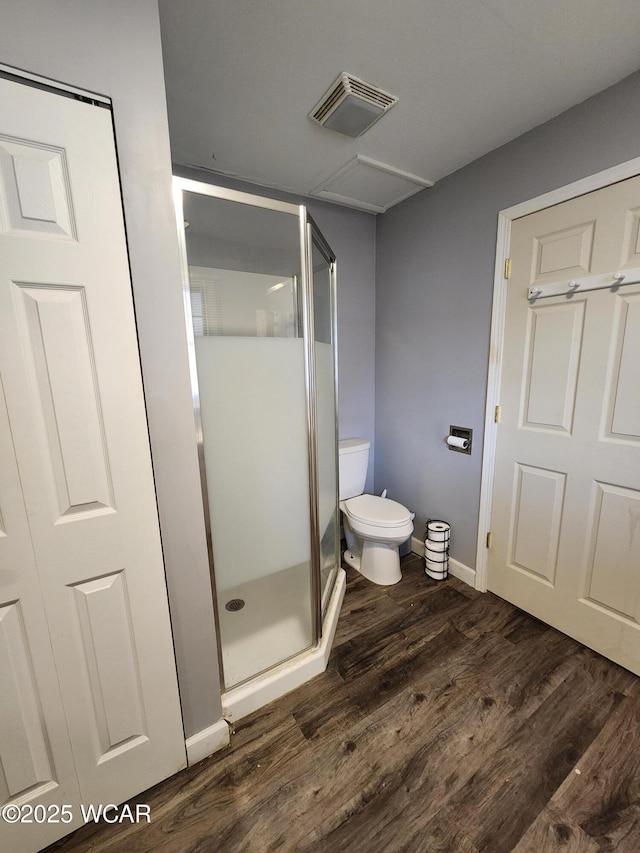 bathroom featuring an enclosed shower, hardwood / wood-style floors, and toilet