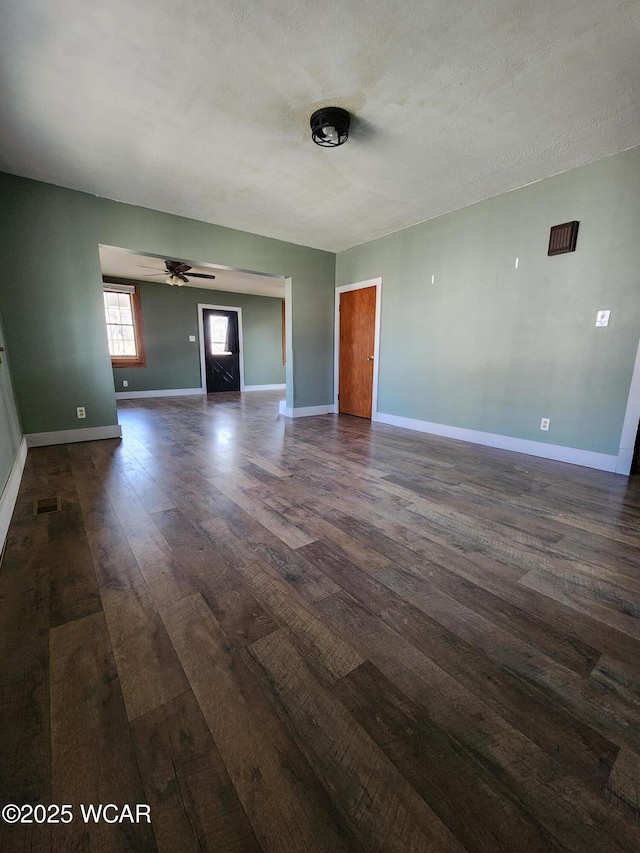 unfurnished living room with a textured ceiling, dark hardwood / wood-style floors, and ceiling fan