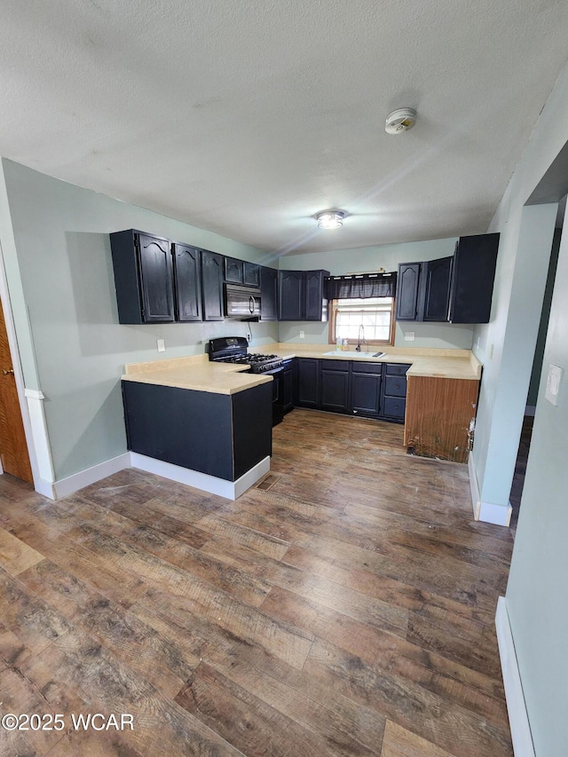 kitchen featuring dark hardwood / wood-style flooring, sink, a textured ceiling, and black appliances