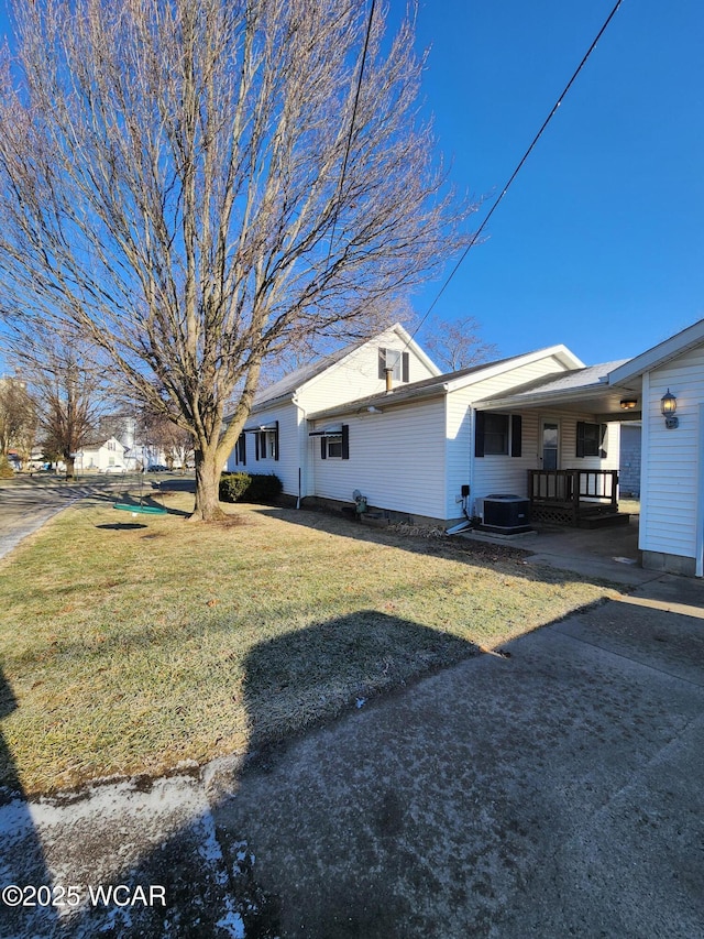 view of side of property featuring a yard and central air condition unit