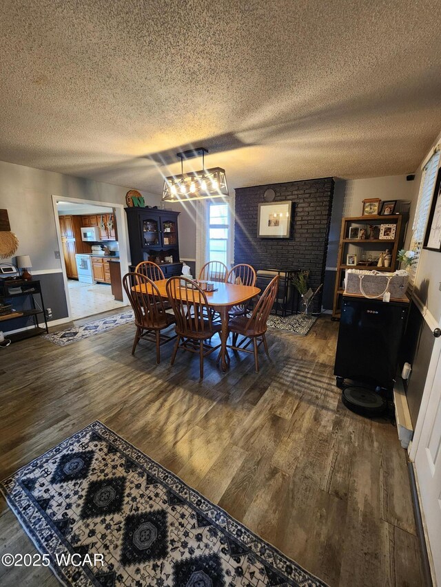 dining area with dark wood-type flooring and a textured ceiling