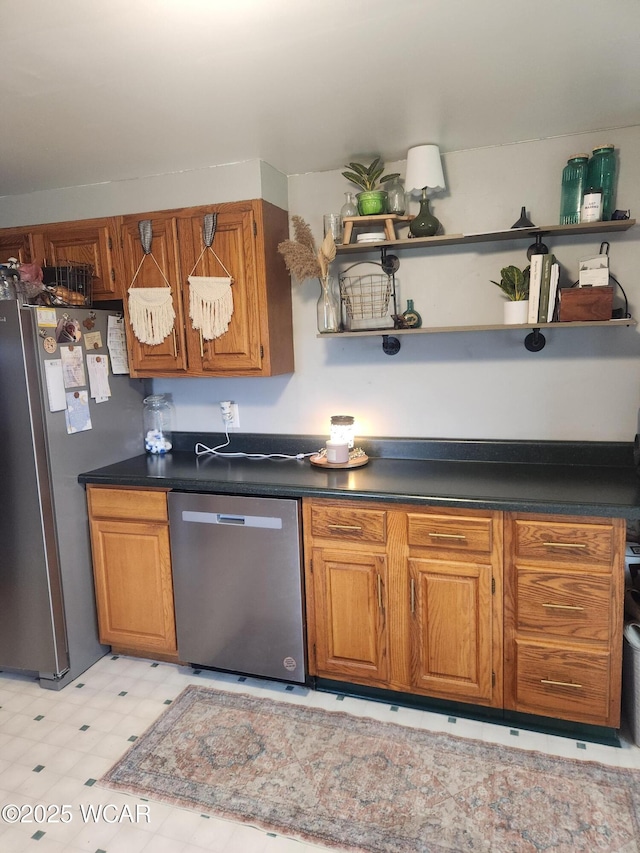 kitchen featuring dark countertops, stainless steel appliances, open shelves, and brown cabinets