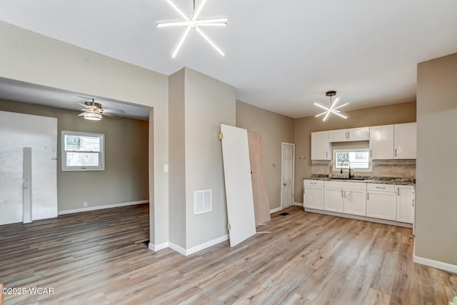 520 Orena Ave, Lima, OH 45804 - kitchen with sink, white cabinetry, tasteful backsplash, dark stone counters, and light wood-type flooring