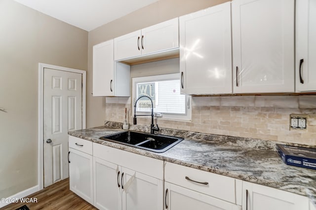 520 Orena Ave, Lima, OH 45804 - kitchen with white cabinetry, tasteful backsplash, sink, and light hardwood / wood-style flooring