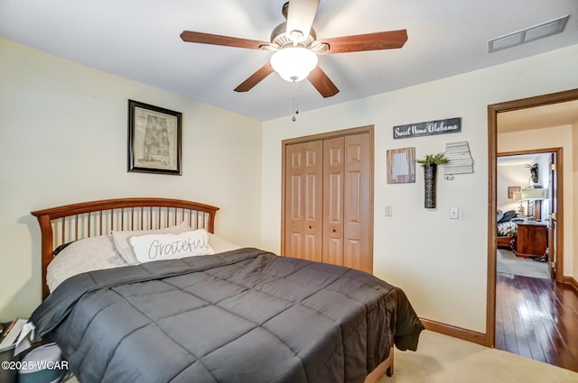 bedroom with dark hardwood / wood-style floors, a closet, and ceiling fan