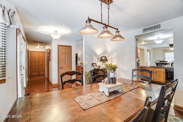 dining room featuring hardwood / wood-style flooring, ceiling fan, and sink