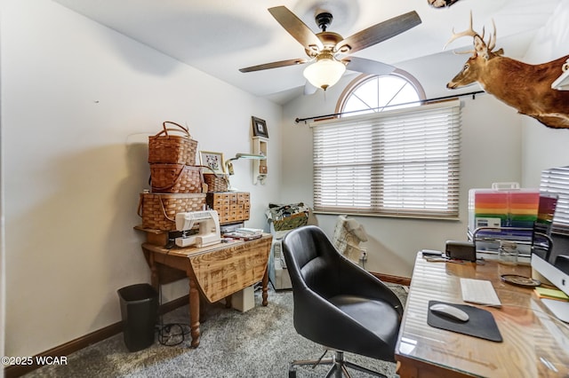 carpeted office space featuring vaulted ceiling and ceiling fan