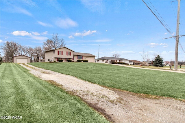 view of front facade featuring driveway, a front yard, a residential view, and a detached garage