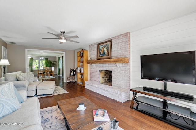 2715 Goldenrod Ln, Findlay, OH 45840 - living room featuring ceiling fan, wood finished floors, a brick fireplace, and a chandelier
