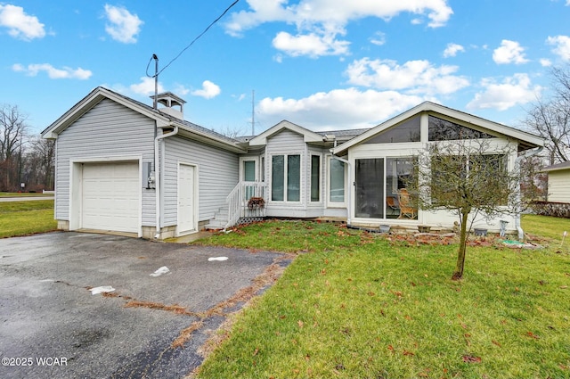 rear view of house with a garage and a yard