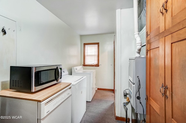 clothes washing area with independent washer and dryer and dark colored carpet