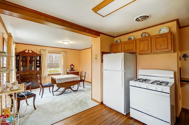 kitchen featuring white appliances, ornamental molding, and light wood-type flooring