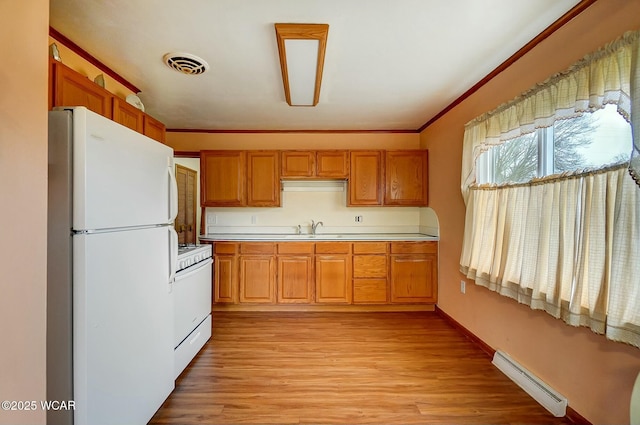 kitchen featuring sink, ornamental molding, a baseboard heating unit, light hardwood / wood-style floors, and white appliances