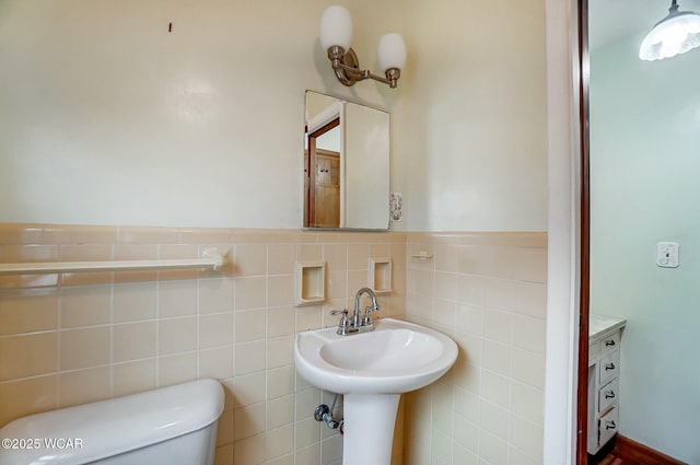 bathroom featuring tile walls and toilet