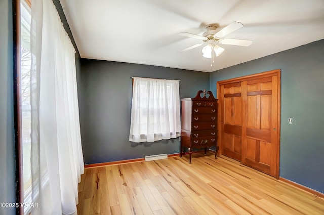 unfurnished bedroom featuring ceiling fan, light hardwood / wood-style floors, and a closet