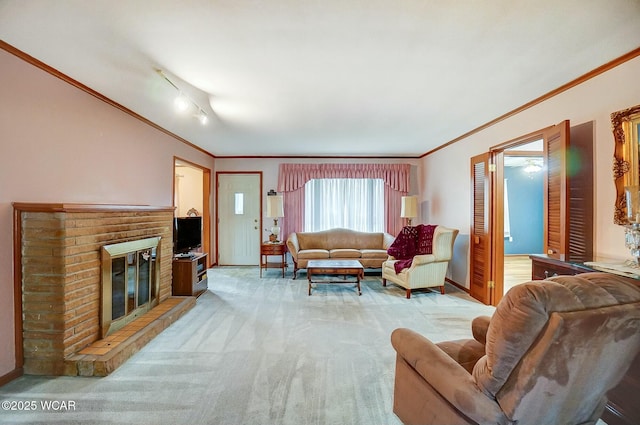 carpeted living room featuring ornamental molding, track lighting, and a fireplace