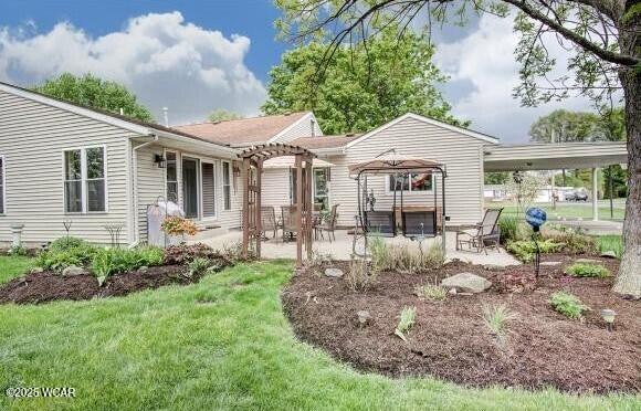 rear view of property with a lawn, a pergola, and a patio