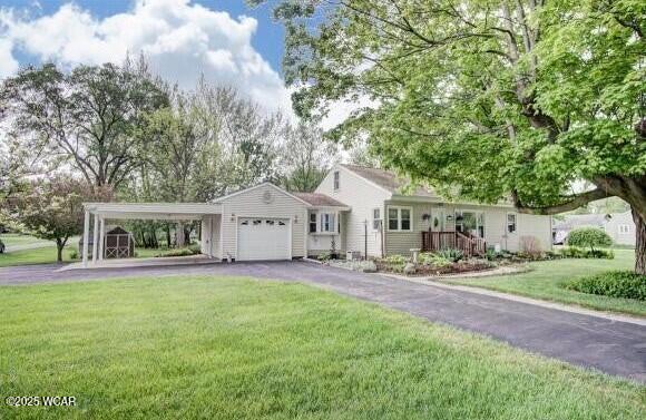 ranch-style home with a carport, driveway, an attached garage, and a front lawn