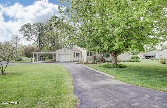 view of front facade with driveway, an attached garage, and a front yard