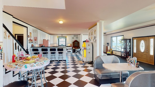 dining space with decorative columns and dark floors