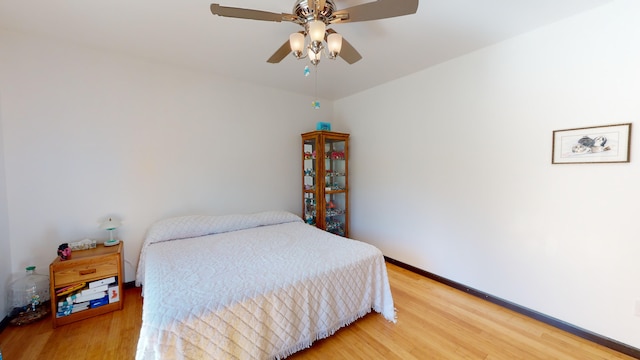 bedroom featuring light wood-style floors, baseboards, and ceiling fan